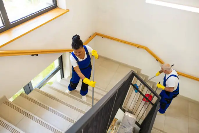 Nahaufnahme einer Frau, die das Treppengeländer putzt