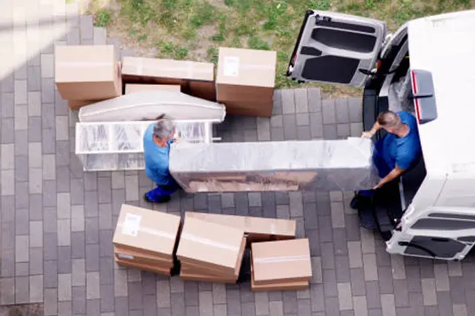 Sauberer, weißer Raum mit Kartons und Putzzeug